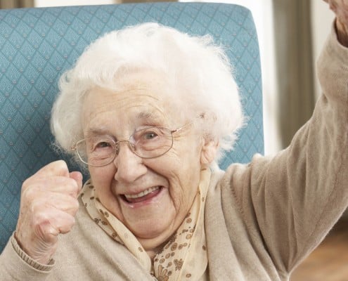 Senior Woman Celebrating In Chair At Home